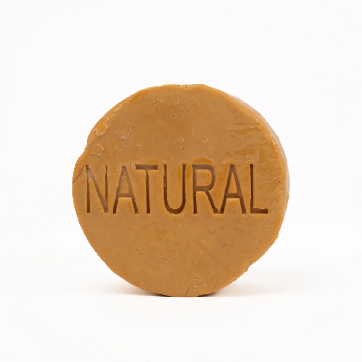 Round cold-process yellow clay solid natural soap bar in kraft packaging